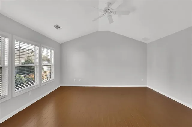 a view of empty room with wooden floor and fireplace