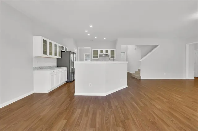 a view of a kitchen with wooden floor and a refrigerator