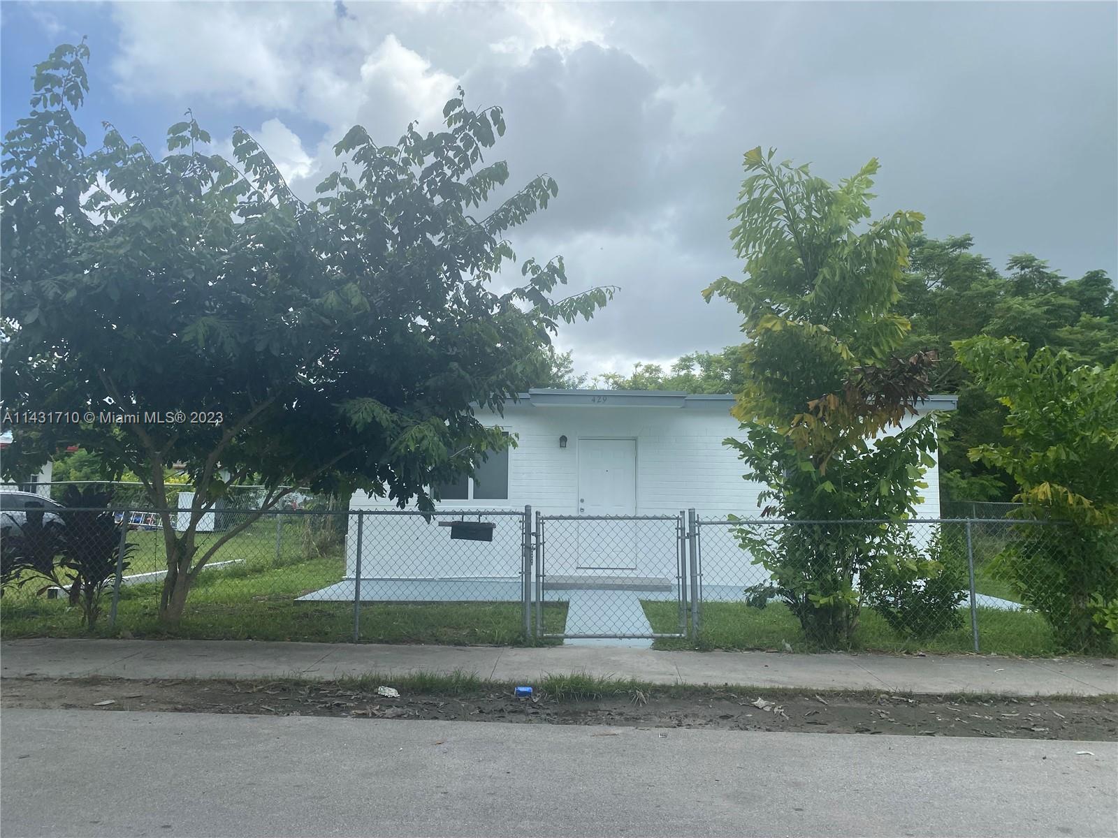 429 Southwest 7th Avenue Homestead, FL 33030 - Photo 2 of 16 a front view of a house with a yard and a garage