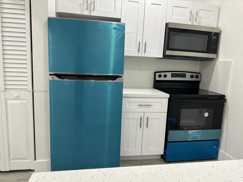 429 Southwest 7th Avenue Homestead, FL 33030 - Photo 5 of 16 a kitchen with a refrigerator and a microwave