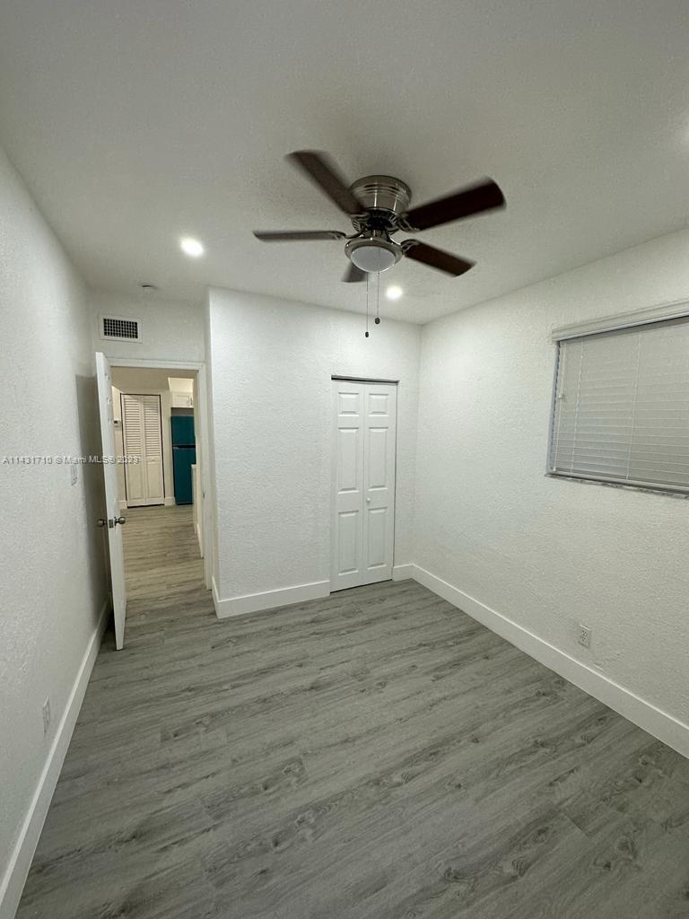 429 Southwest 7th Avenue Homestead, FL 33030 - Photo 8 of 16 an empty room with wooden floor and windows