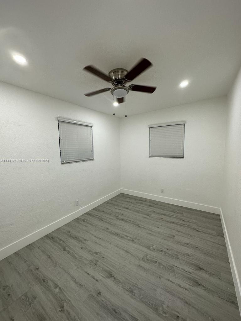 429 Southwest 7th Avenue Homestead, FL 33030 - Photo 9 of 16 a view of an empty room with wooden floor and a ceiling fan