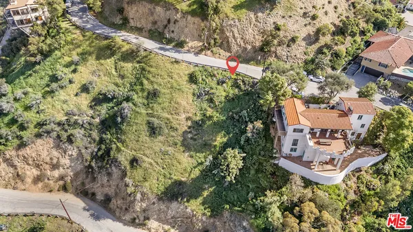 an aerial view of residential house with outdoor space and trees all around