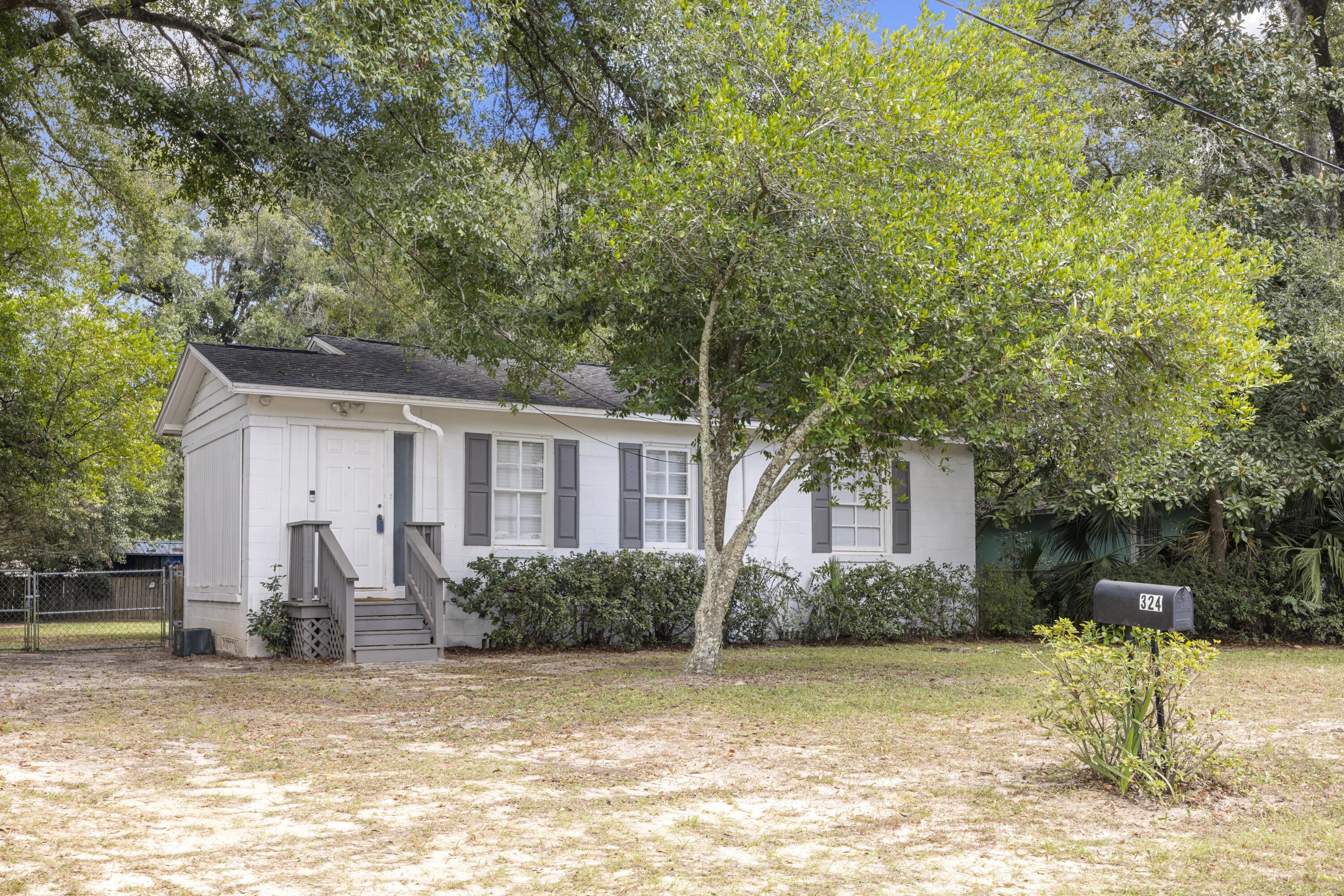a front view of a house with a yard and trees