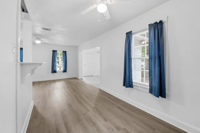 a view of a livingroom with wooden floor and a large window