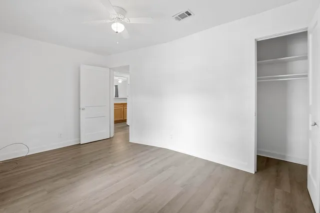 an empty room with wooden floor and closet