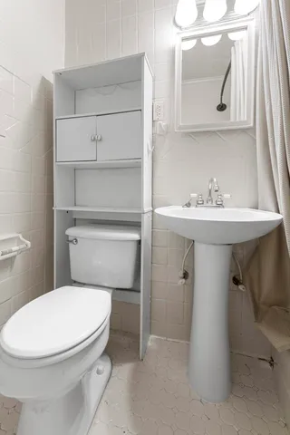 a bathroom with a toilet a sink and a mirror