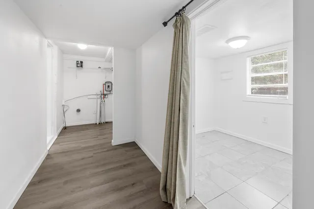 a view of a hallway with wooden floor and staircase