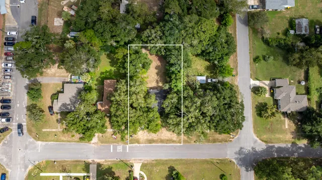 an aerial view of a residential houses with yard