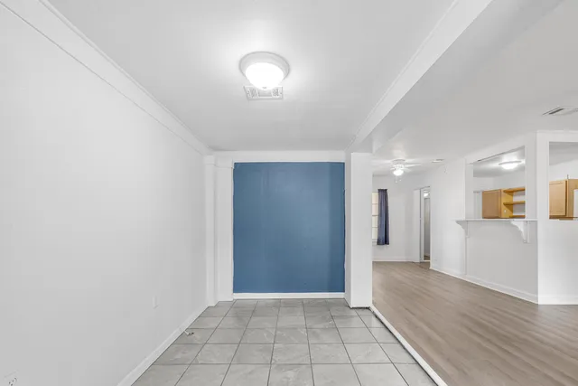 a view of a hallway with wooden floor and a living room