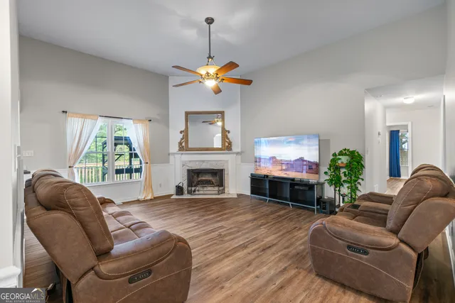 a living room with furniture a fireplace and a flat screen tv