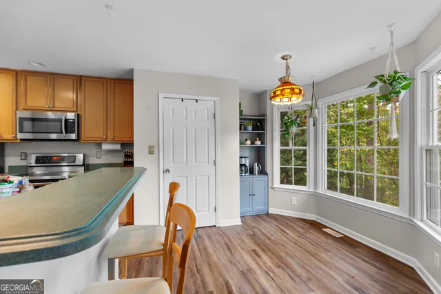 a kitchen view with wooden floors wooden cabinets and stainless steel appliances