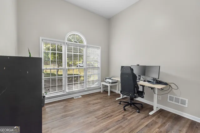 a view of a workspace with furniture and a window