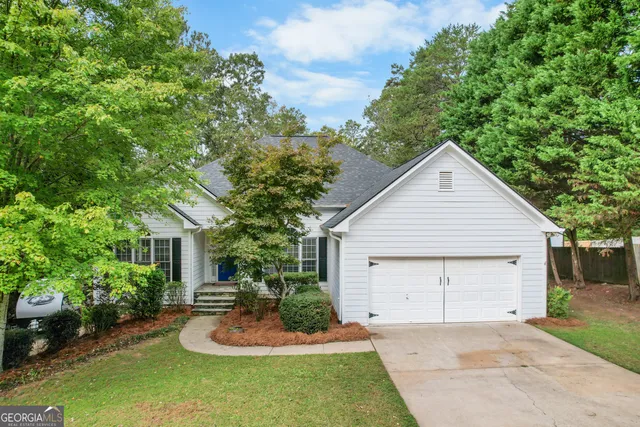 a view of a house with a yard and potted plants