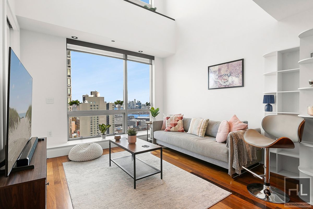 a living room with furniture a rug and a large window