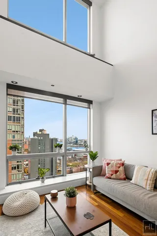 a living room with furniture a rug and a large window