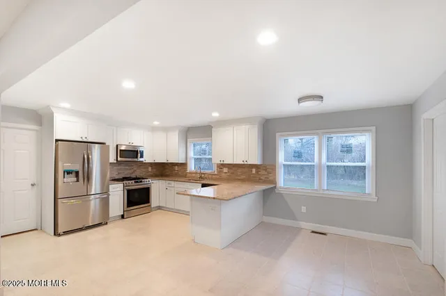 a kitchen with refrigerator and windows