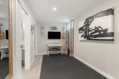 a view of a livingroom with wooden floor and a flat screen tv