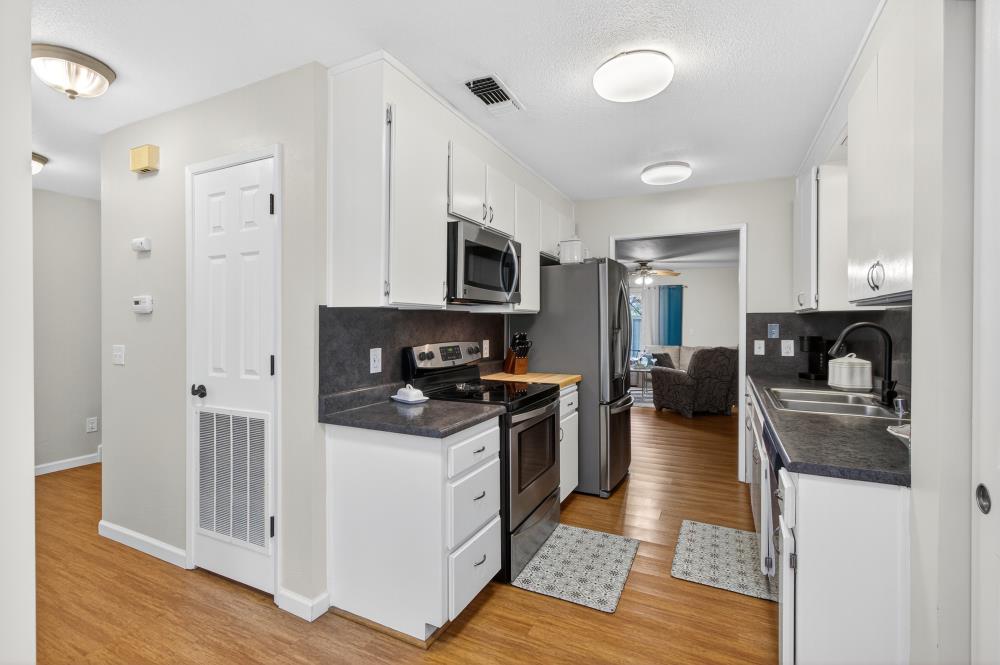 750 Lincoln Road, Unit 62 Yuba City, CA 95991 - Photo 14 of 56 a kitchen with stainless steel appliances granite countertop a stove top oven a refrigerator a sink and dishwasher with wooden floor