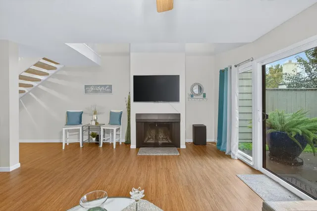a dining room with wooden floor a chandelier a glass table and chairs