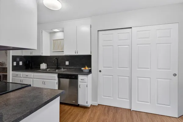 a kitchen with granite countertop a sink a stove and cabinets