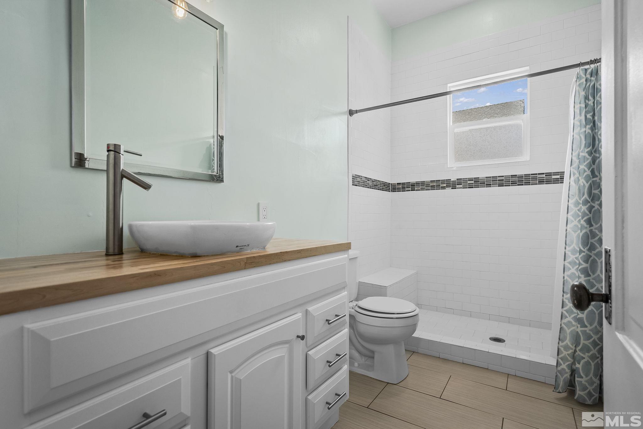 546 Sinclair Street Reno, NV 89501 - Photo 14 of 27 a bathroom with a granite countertop sink a toilet and shower