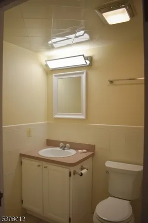 a bathroom with a toilet a sink and mirror