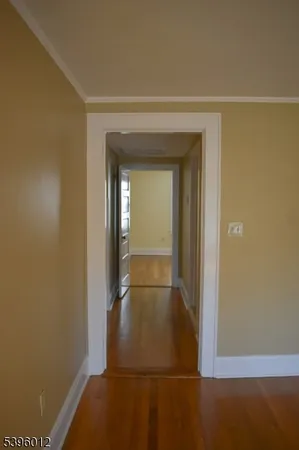 a view of room with hardwood floor and hallway