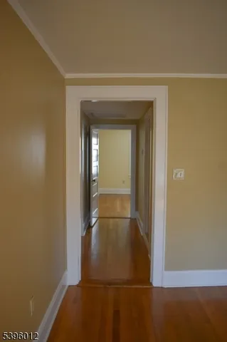 a view of room with hardwood floor and hallway