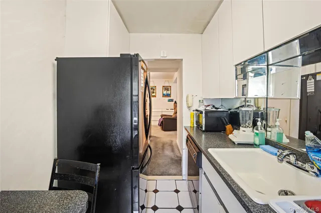 a room with a table chairs and refrigerator