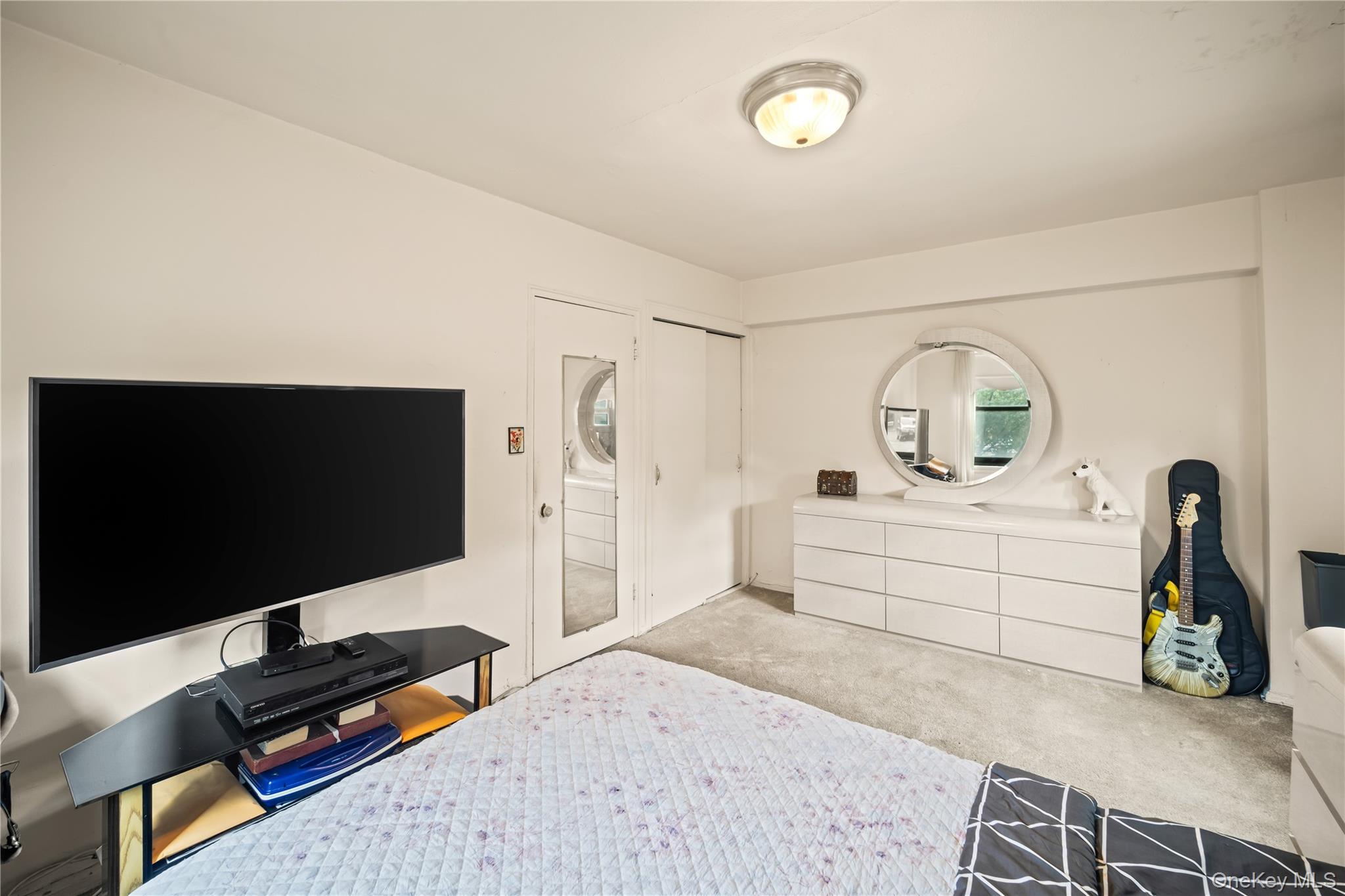 211-02 75th Avenue, Unit 1L Queens, NY 11364 - Photo 10 of 16 a bedroom with a bed and a flat screen tv