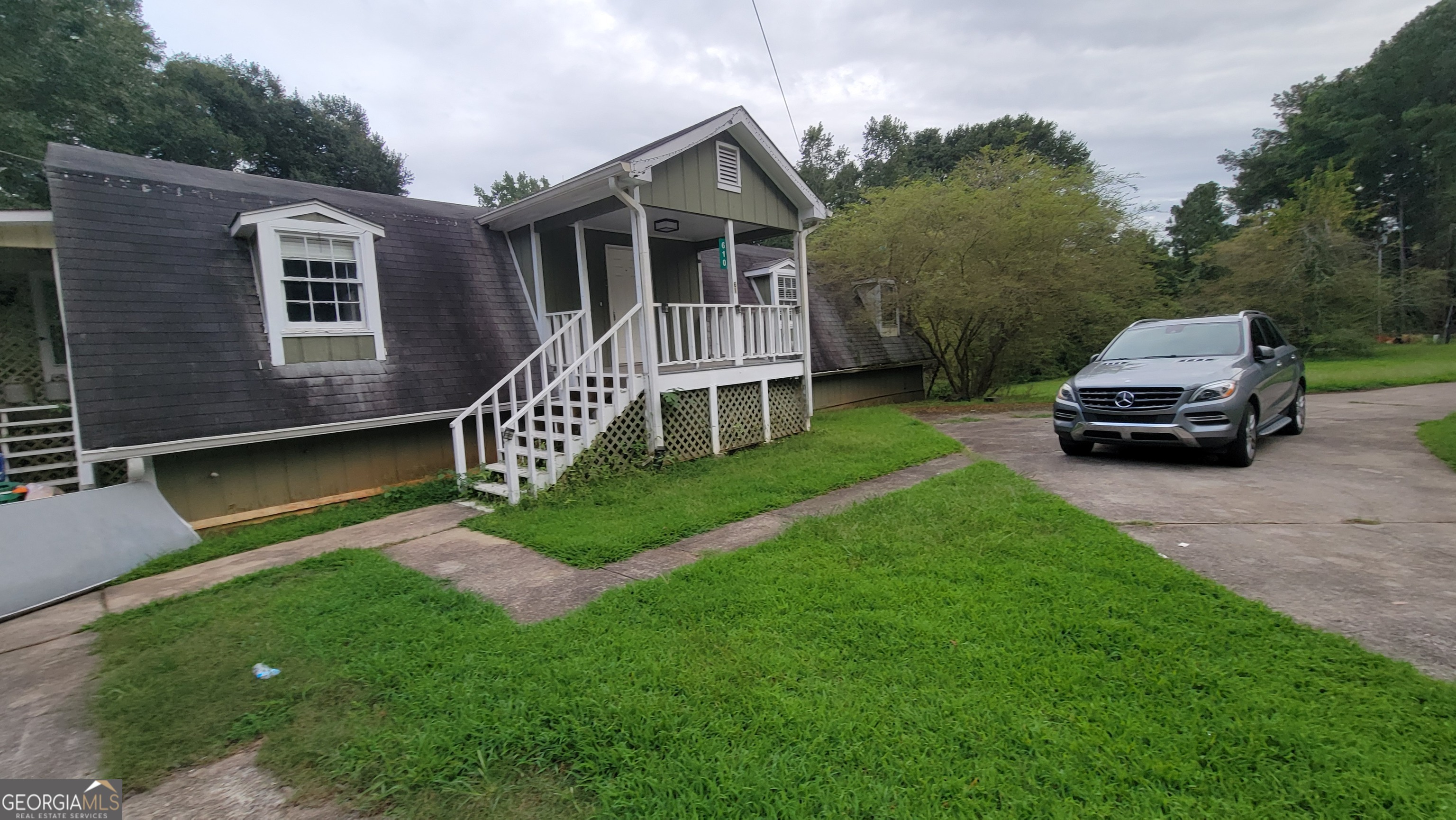 a car parked in front of a house with a yard