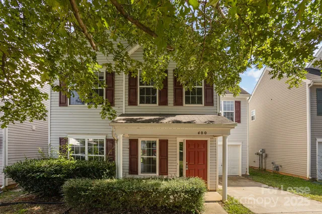 two view of a house with a yard and potted plants