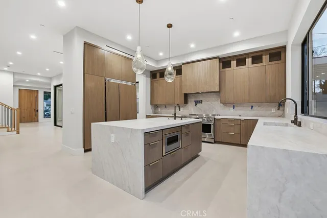 a kitchen with stainless steel appliances a sink stove and refrigerator