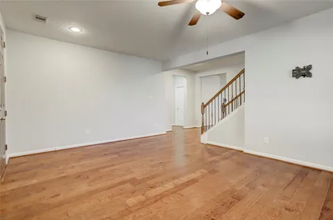 a view of an empty room with a chandelier fan
