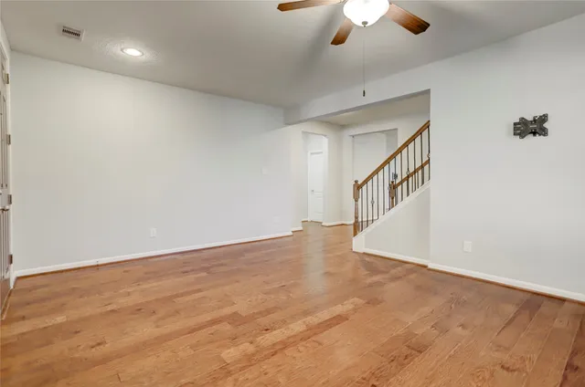 a view of an empty room with a chandelier fan