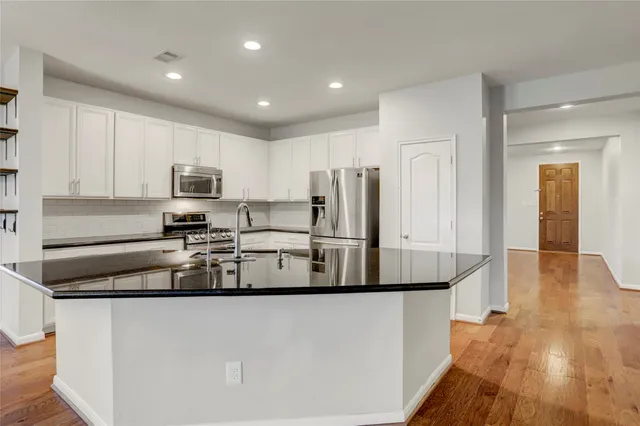 a view of an empty room with kitchen appliances and a window