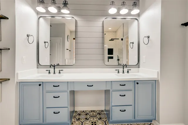 a bathroom with a double vanity sink a mirror a bathtub and shower