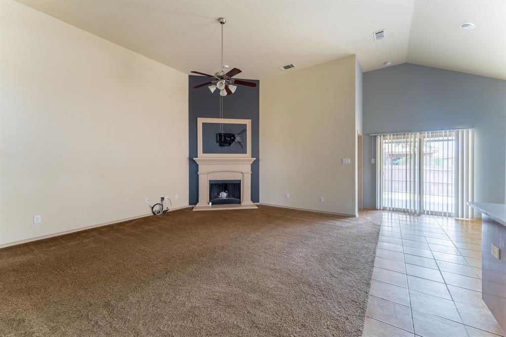 11156 Hawks Landing Road Fort Worth, TX 76052 - Photo 4 of 30 Living area featuring a fireplace with a light-toned mantelpiece, a ceiling fan, and vaulted ceilings