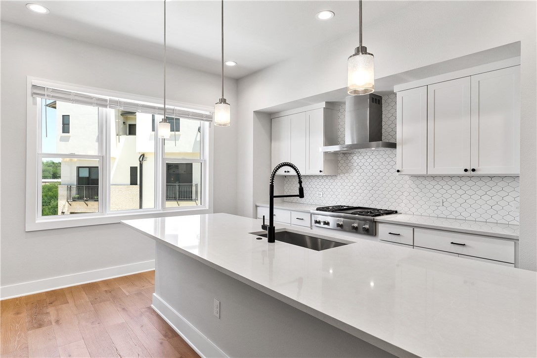 4611 Unity Circle Austin, TX 78731 - Photo 15 of 40 The gourmet kitchen includes Silestone countertops, a gas cooktop, a double oven, and a stainless refrigerator.