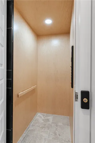 a large kitchen with kitchen island a stove a sink a refrigerator and white cabinets with wooden floor