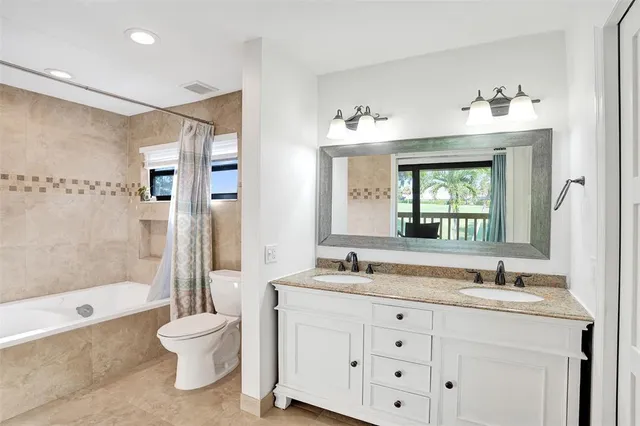 a bathroom with a sink vanity mirror and toilet