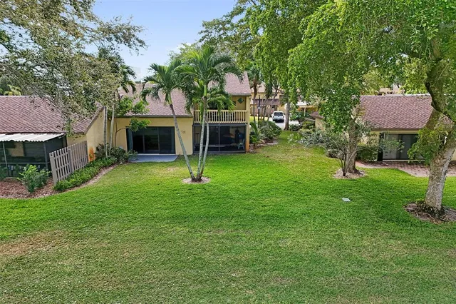 a front view of a house with a yard and tree