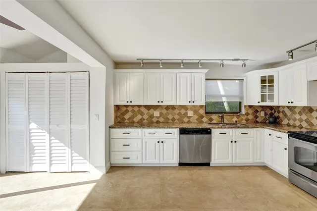 a kitchen with granite countertop a sink and cabinets