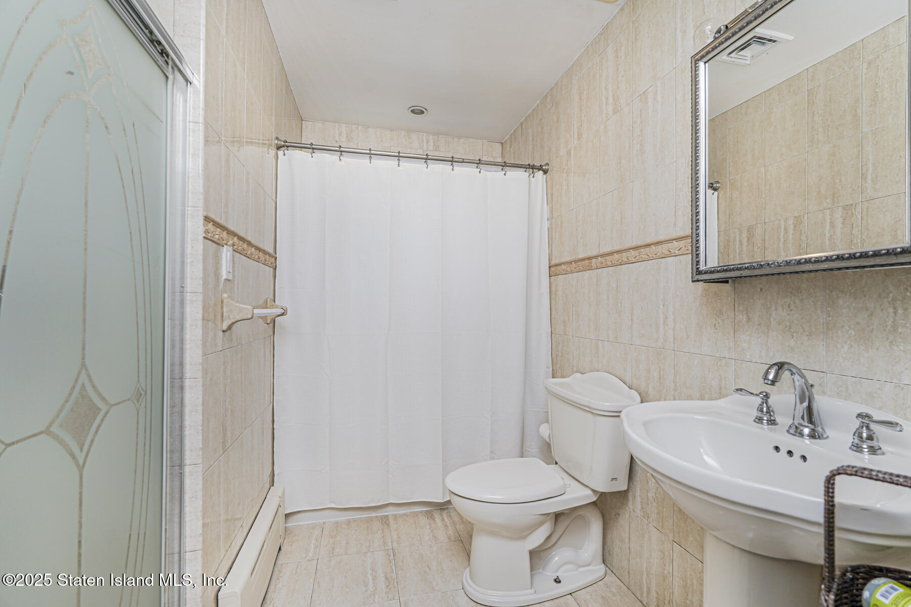 82 Woods Of Arden Road Staten Island, NY 10312 - Photo 13 of 30 a white toilet sitting next to a bathroom sink