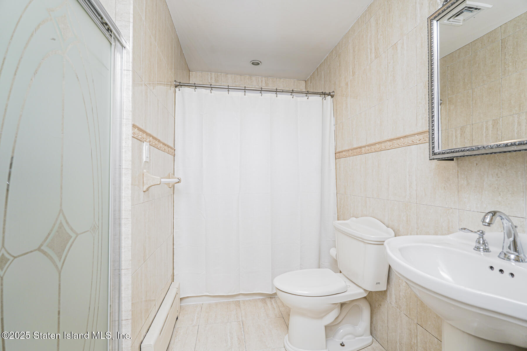 82 Woods Of Arden Road Staten Island, NY 10312 - Photo 14 of 30 a white toilet sitting next to a bathroom sink