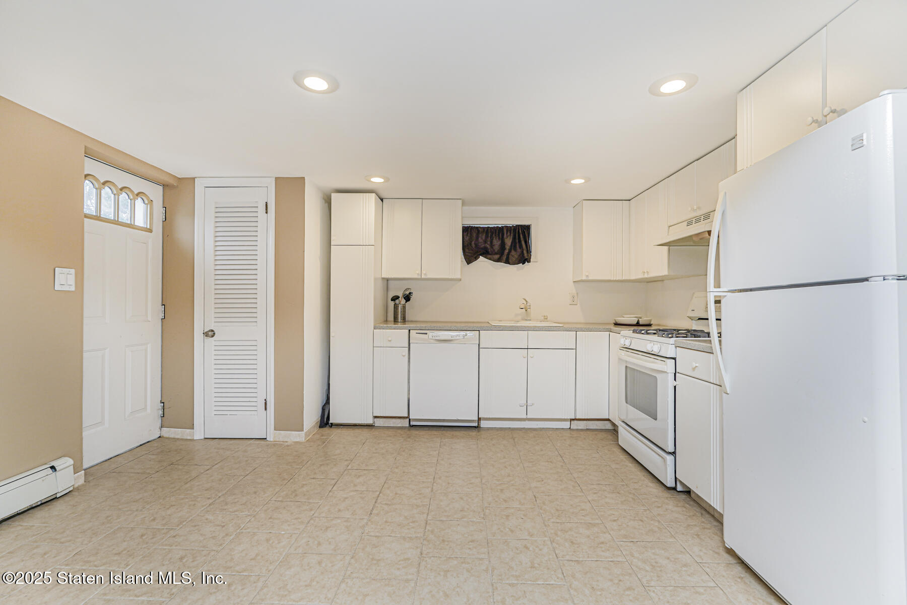 82 Woods Of Arden Road Staten Island, NY 10312 - Photo 25 of 30 a kitchen with white cabinets and white appliances