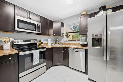 a kitchen with stainless steel appliances granite countertop a refrigerator and a stove top oven