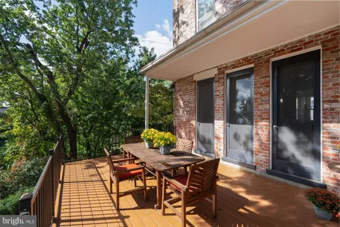 a view of yard with wooden deck and trees