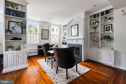 a living room with furniture a rug and a bookshelf